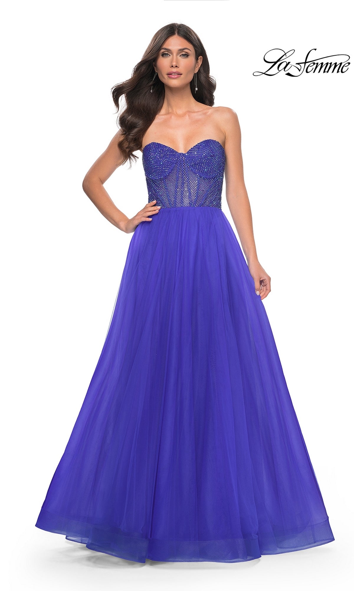 A woman poses in the La Femme Strapless Long A-Line Prom Dress 32216, featuring a beaded bodice and tulle skirt, against a white background for a stunning formal look.